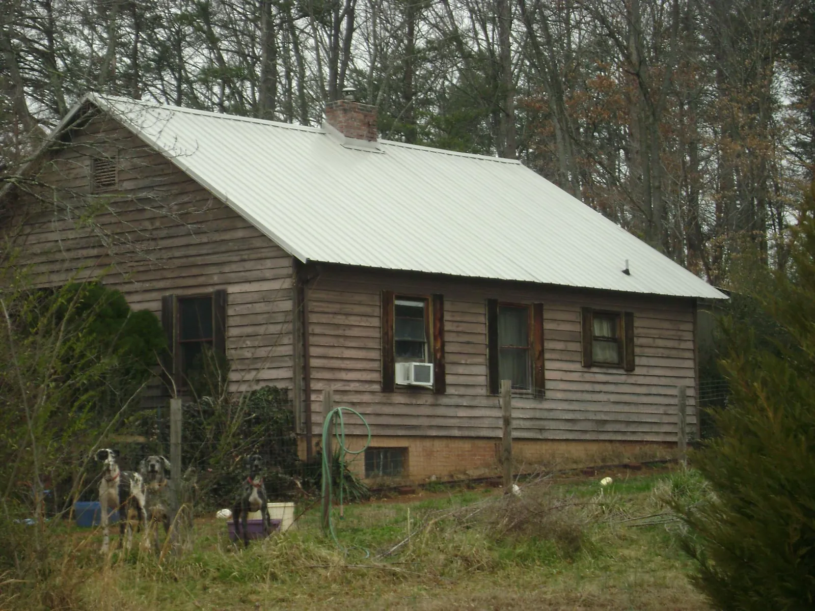 White metal roof on an old wood sided farmhouse, from a Metal Roof Installation job in Maple City